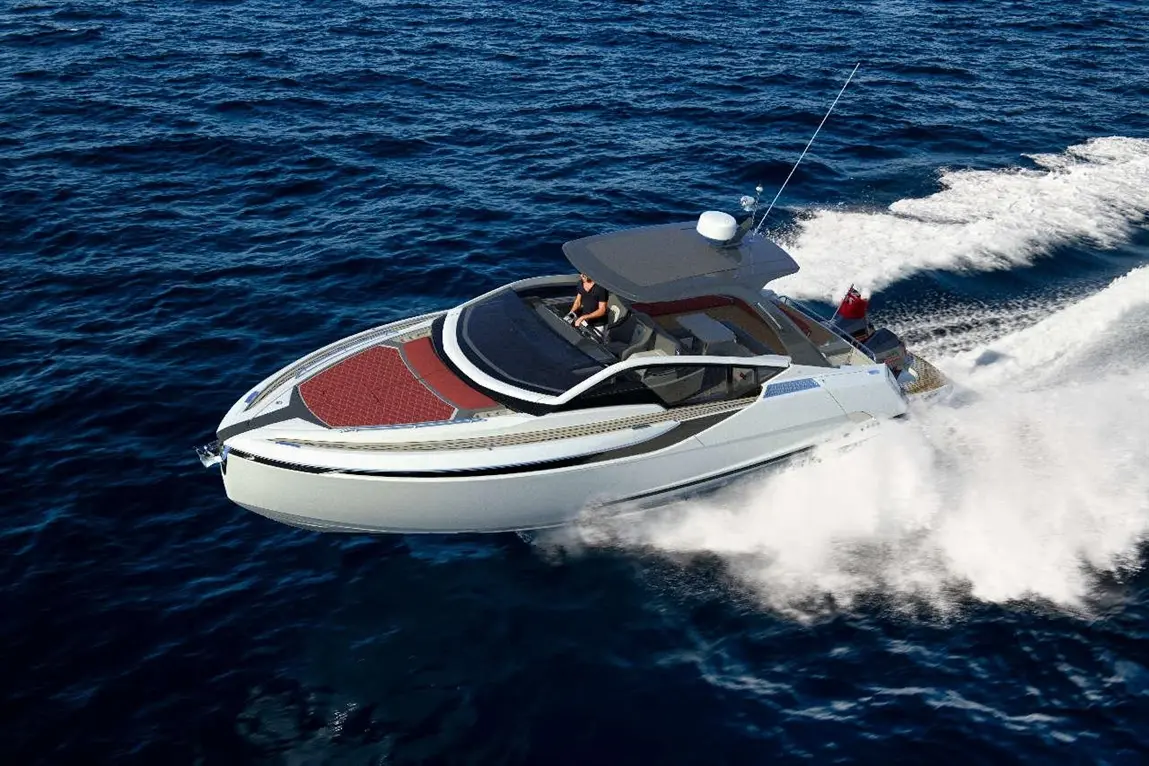 Luxury motorboat speeding across deep blue ocean with a man at the helm, leaving a wake behind.